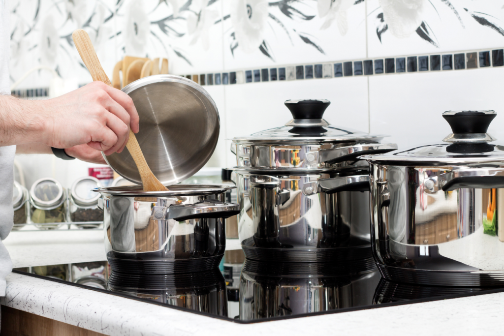 someone stirring a pot while cooking on an induction cooktop